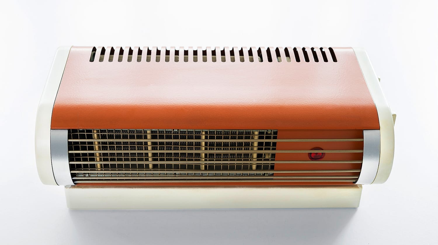 Kompakter Heizlüfter mit orangefarbenem Oberteil, Metallgitter und rotem Kontrolllicht. Ideal für angenehme Wärme.