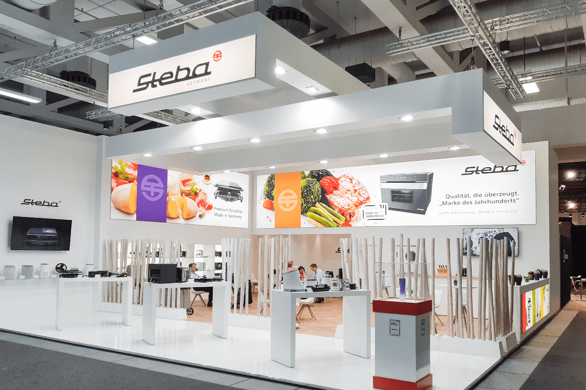 Messestand von Steba mit Elektrogeräten, einschließlich Raclette-Grill, und Informationen zur Markenqualität.