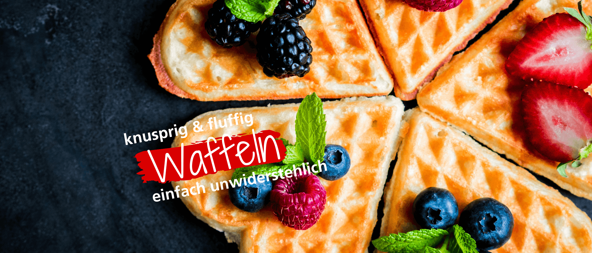 Fluffige Waffeln auf dunklem Untergrund, dekoriert mit frischen Beeren und Minze. Ideal für ein köstliches Frühstück.